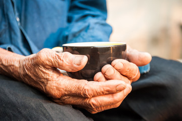 A cup of coffee on old hand