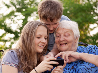 Young and old woman examine the image in phone