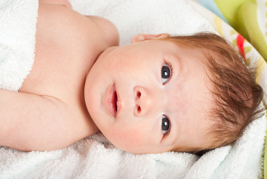 Surprised newborn baby boy after bath