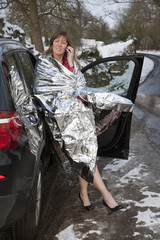 Woman driver wrapped in foil blanket on phone