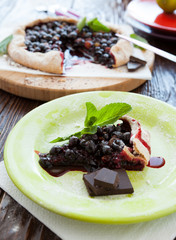 piece of berry pie on the background of the whole pie