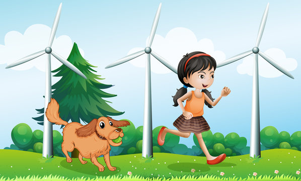 A girl playing with her dog near the windmills