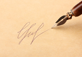 Closeup of signature (fake, not real) and ink pen, on old paper