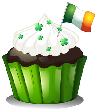 A chocolate cupcake with clover plants and the flag of Ireland