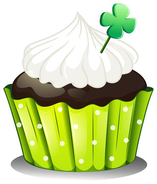 A chocolate cupcake with a green plant
