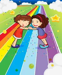 Selbstklebende Fototapete Regenbogen Zwei Mädchen, die ihre Hände an der bunten Straße halten