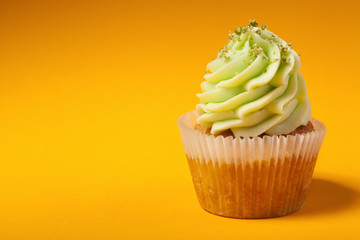 cupcake with cream isolated on orange background with copyspace