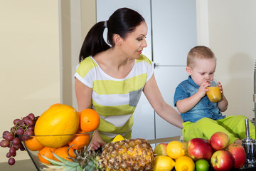 Mother and child making fresh orange juice - healthy life