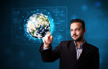 Young businessman touching high-tech 3d earth panel