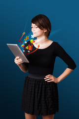 Young woman looking at modern tablet with abstract lights and va