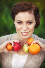 Happy woman and spring fruits. brunette girl on nature