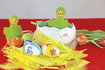 Fototapeta na wymiar grüne Ente im Nest mit Ostereiern und Tulpen