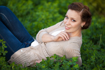 Happy woman resting on spring nature. Brunette girl at park