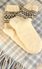 Warm knitted socks on plaid close-up
