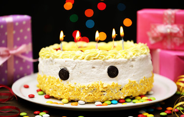 Happy birthday cake and gifts, on black background