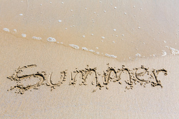Summer handwritten inscription in sand on a beach