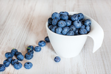 White bowl cup with fresh ripe blueberries