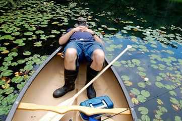Fisherman asleep in his canoe