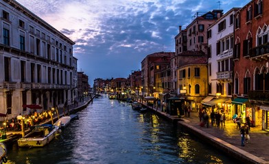 Venice channel at nightfall, with people (unrecognizable)
