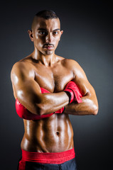 Fototapeta na wymiar Boxer z czerwonym rękawice w ciemnym pokoju