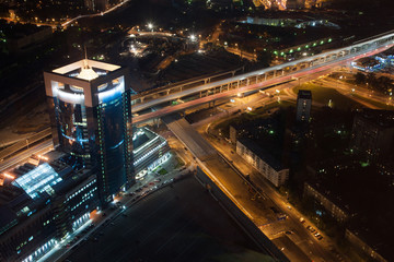 Fototapeta na wymiar Night cityscape with high luminous buildings, bridges and road.