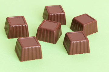 Chocolates candy close-up on green background.