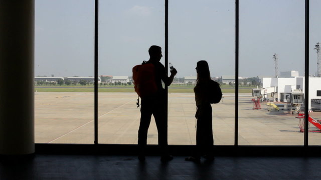 silhouette of pair of lovers near the window in airport