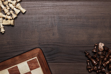 some chess figures and board over woden background