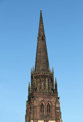 Fototapeta na wymiar The Spire of a Country Church Against a Blue Sky.