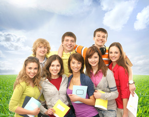 Group of smiling teenagers staying together and looking at camer