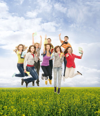 Group of teenagers jumping together on a green background