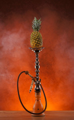 Exotic hookah with the fruit on the top over vintage background