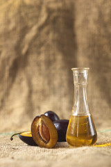 Plum brandy with fresh and tasty plum fruit on a table cloth.