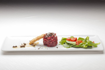 Elegant Seasoned beef tartare with black truffles. Gourmet Delic