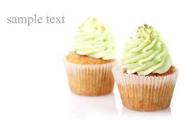 two cupcakes with green cream isolated on white background with