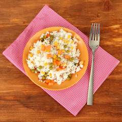 Risotto on color plate on wooden background