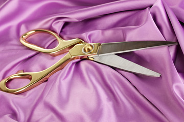 Metal scissors on purple fabric