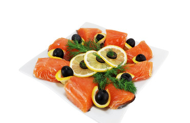 pieces of salmon with olives and lemon on a plate