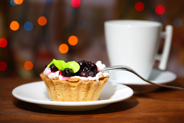 Tasty blackberry cake and cup of beverage,