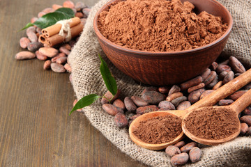 Cocoa powder and cocoa beans  on wooden background