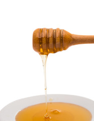 Honey dripping from a wooden honey dipper