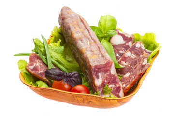 Ripe salami with salad, basil, onion and tomato