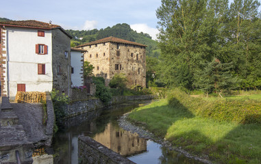 Fototapeta na wymiar beautiful rural houses along the River in the Pyrenees, Etxalar,