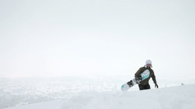 Snowboarder mit Board geht durch den Schnee