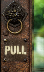Pull sign on old metal door.