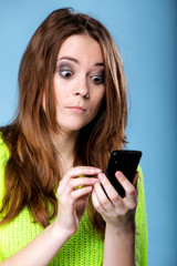 Woman texting while looking surprised on phone