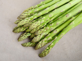 fresh green asparagus sprouts laying on bamboo background