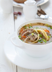 meat soup with vermicelli in a white tureen