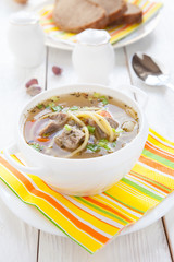nourishing soup with vermicelli and beef in a white tureen
