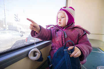 Adorable girl in winter clothes ride city bus and look to window © Joshhh